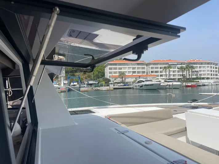  Yacht Photos Pics Modern Bali 5.4 yacht docked at marina with luxury apartments in background, 2023 model.