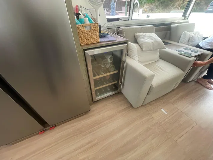  Yacht Photos Pics Modern yacht interior with mini fridge, beige seating, and wooden flooring on a 2023 Bali 5.4.