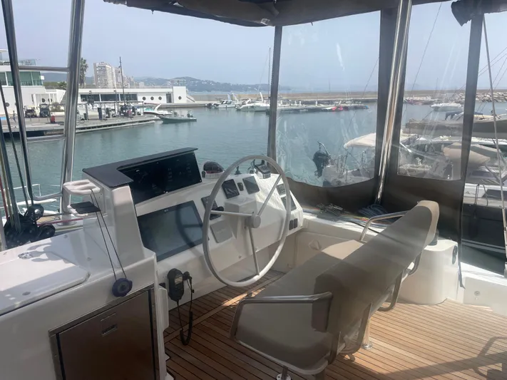  Yacht Photos Pics Interior view of a 2023 Bali 5.4 yacht cockpit with steering wheel and navigation equipment.