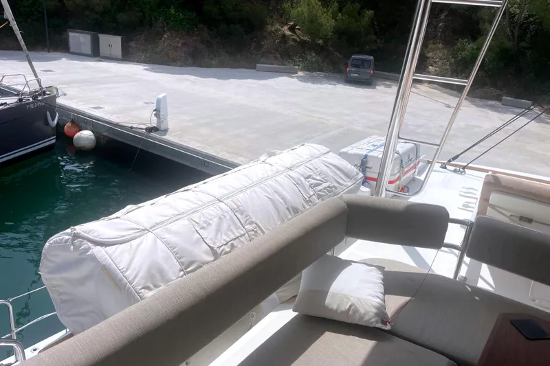  Yacht Photos Pics 2023 Bali 5.4 yacht docked at marina with cushioned seating area.