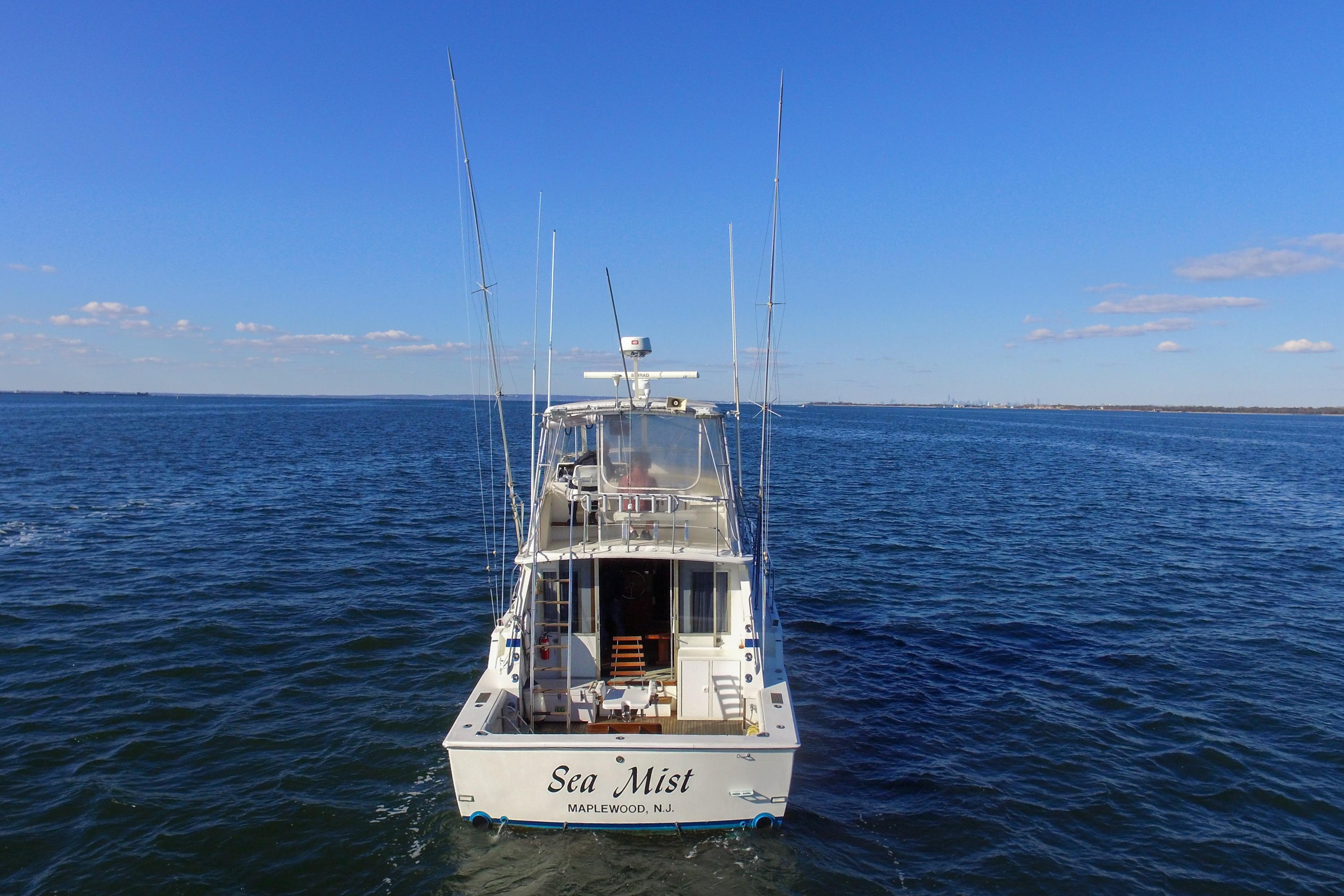1980 Bertram 42 Convertible boat "Sea Mist" on open water under clear blue sky.