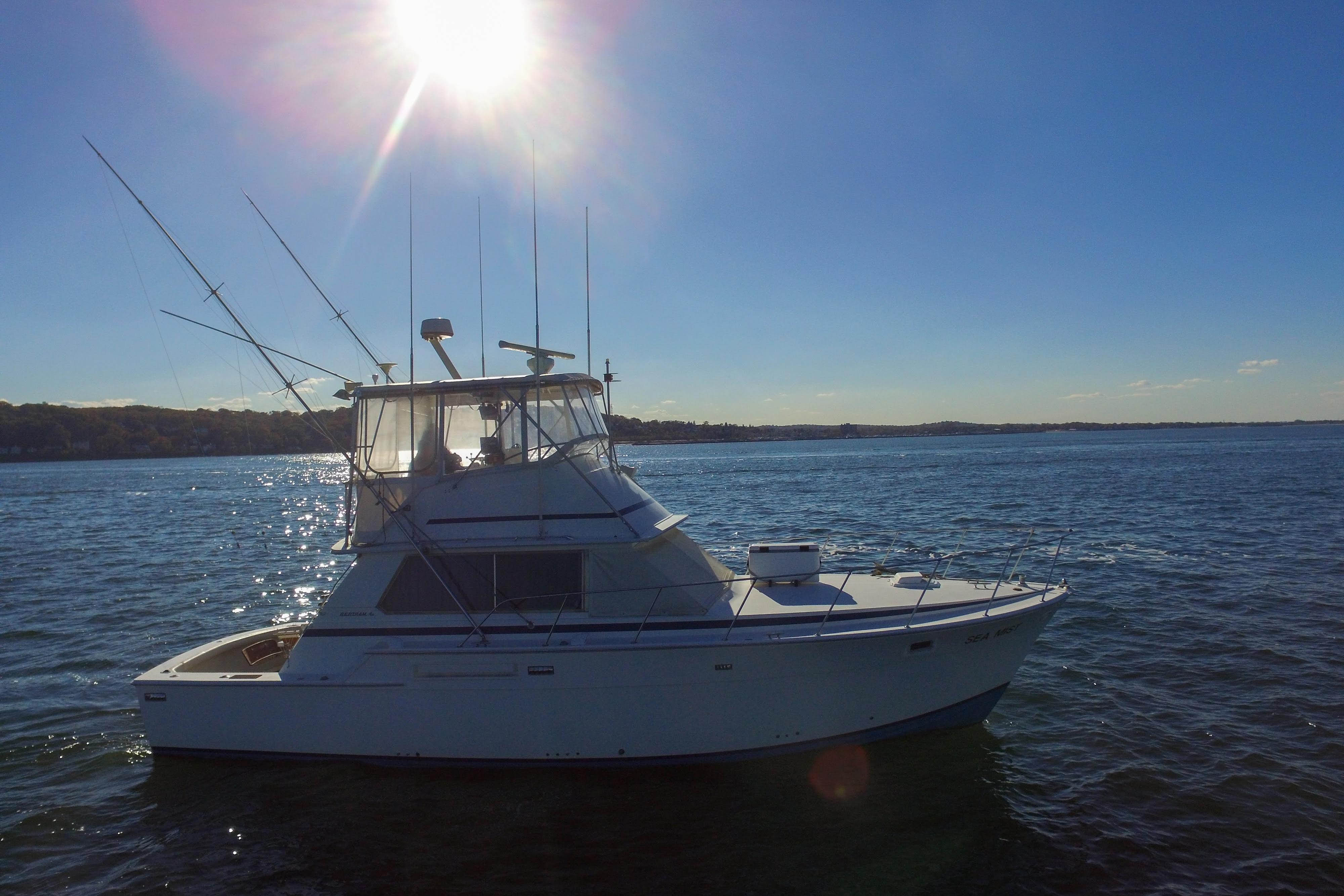 1980 Bertram 42 Convertible yacht on open water under bright sun.