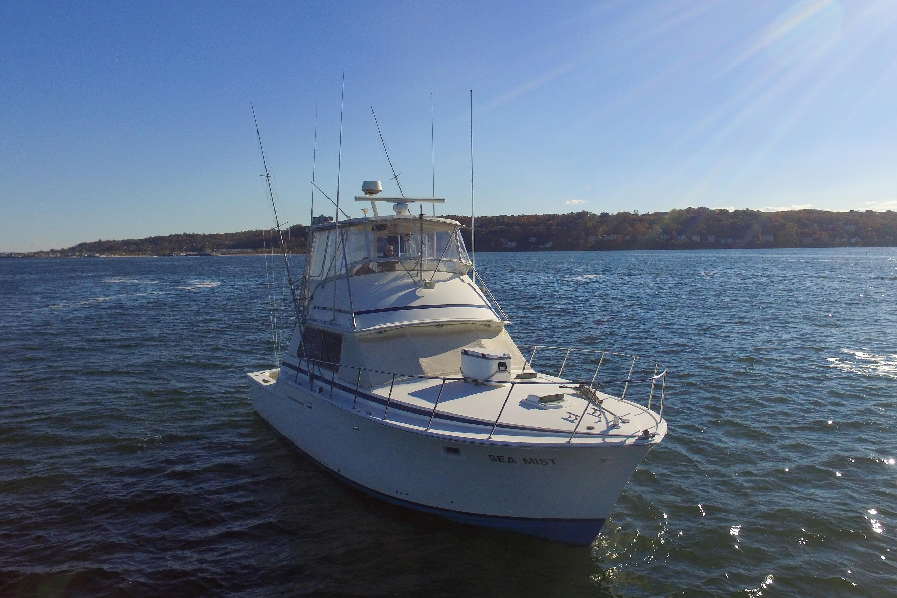 1980 Bertram 42 Convertible yacht "Sea Mist" on calm waters under clear blue sky.