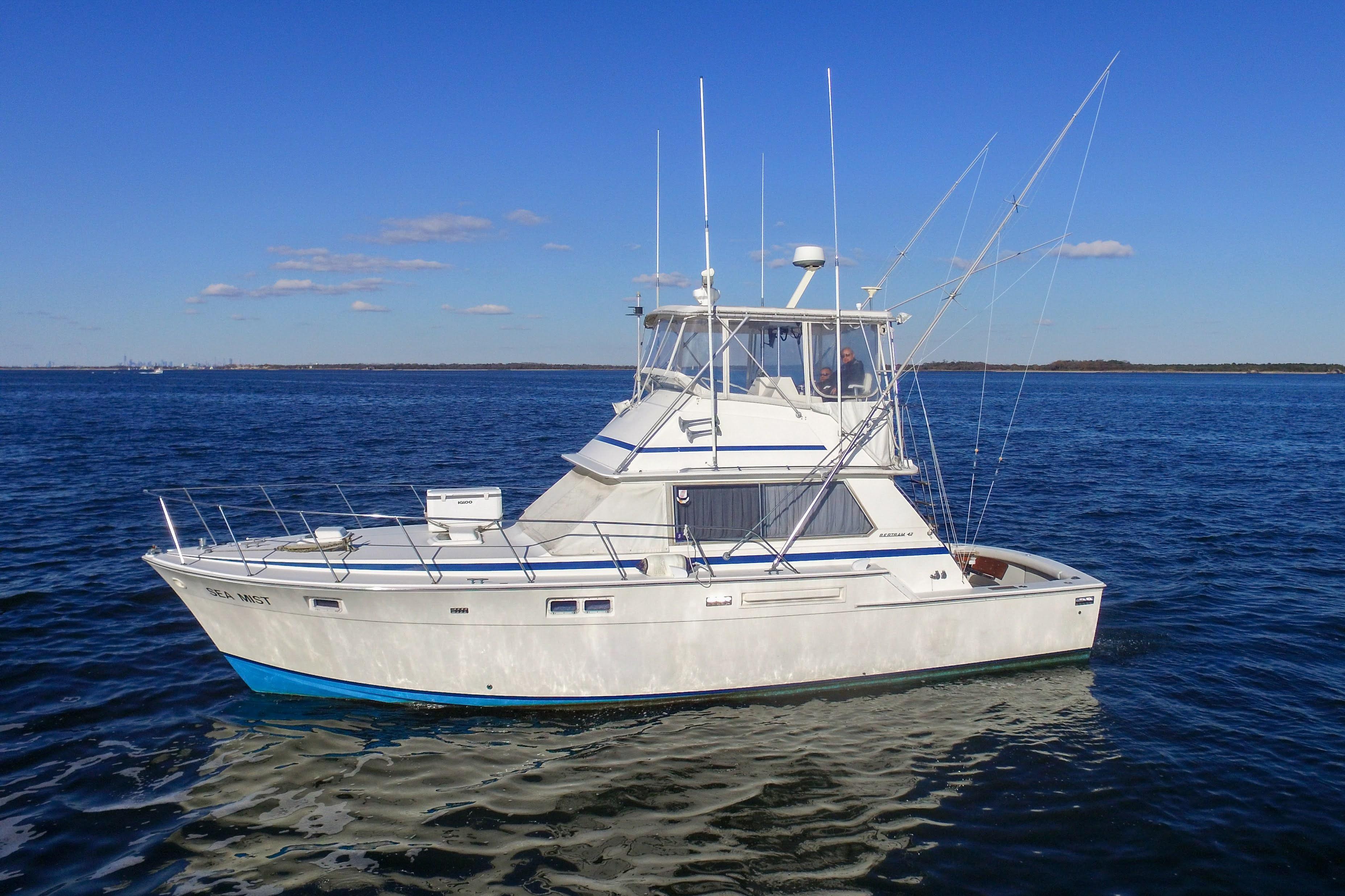 1980 Bertram 42 Convertible yacht cruising on open water under clear blue skies.