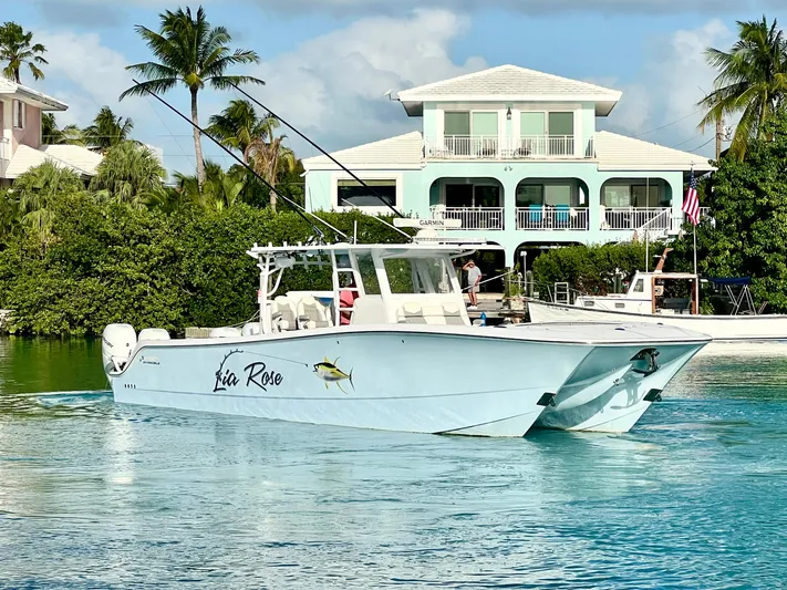 Lia Rose Yacht Photos Pics Invincible 46 Catamaran 2022 cruising near waterfront homes, tropical setting.