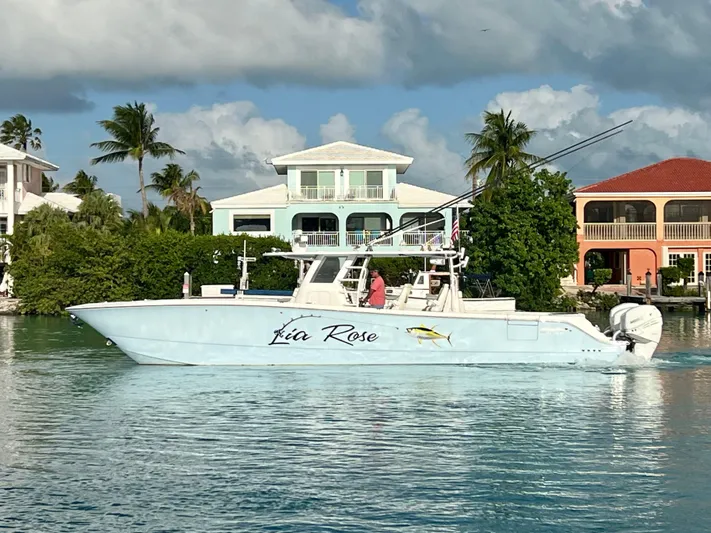 Lia Rose Yacht Photos Pics Invincible 46 Catamaran 2022 cruising near waterfront homes under a cloudy sky.