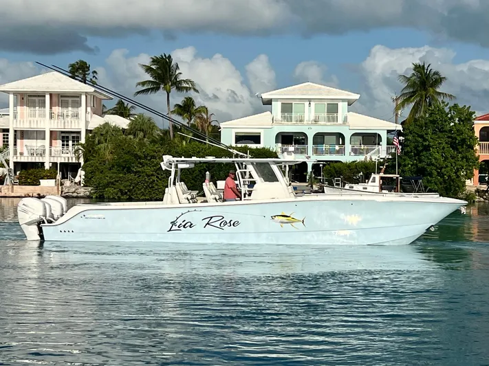 Lia Rose Yacht Photos Pics Invincible 46 Catamaran 2022 on water, with coastal homes and palm trees in the background.