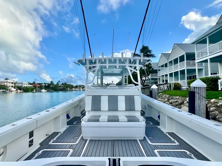 Lia Rose Yacht Photos Pics 2022 Invincible 46 Catamaran docked by waterfront homes under a blue sky.
