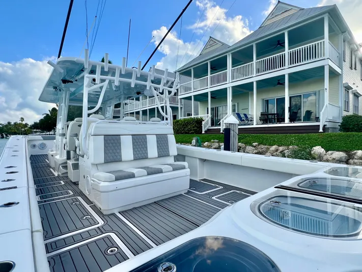 Lia Rose Yacht Photos Pics Invincible 46 Catamaran 2022 docked near waterfront homes, showcasing spacious deck and seating.