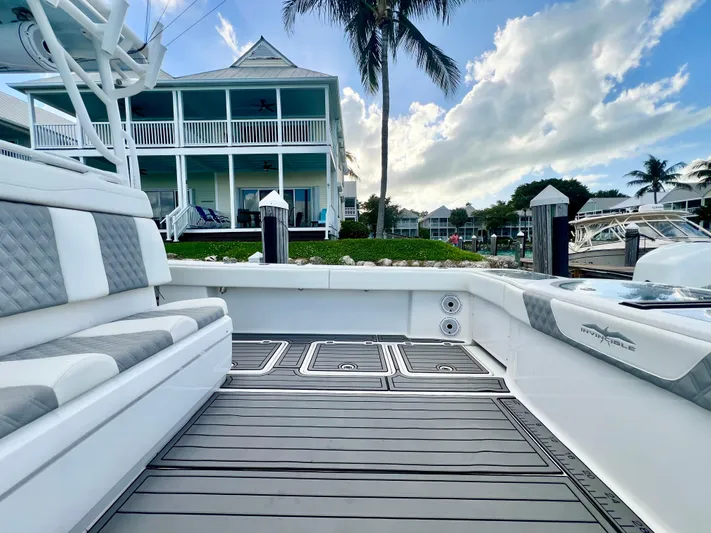Lia Rose Yacht Photos Pics Invincible 46 Catamaran 2022 docked near waterfront home, showcasing spacious deck and seating.