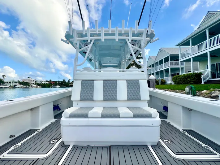 Lia Rose Yacht Photos Pics 2022 Invincible 46 Catamaran with sleek seating, docked near waterfront homes.