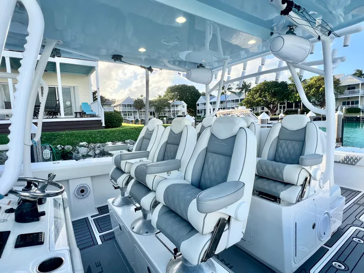 Lia Rose Yacht Photos Pics Luxurious seating on 2022 Invincible 46 Catamaran, docked near waterfront homes.