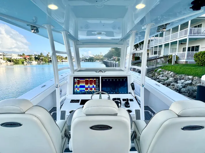 Lia Rose Yacht Photos Pics Invincible 46 Catamaran 2022 cockpit with dual screens, luxurious seating, and waterfront view.