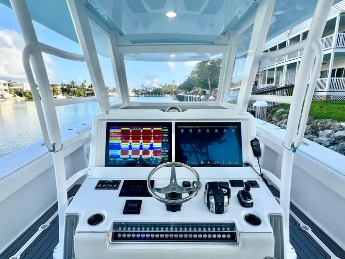 Lia Rose Yacht Photos Pics Invincible 46 Catamaran 2022 helm with advanced navigation screens and controls, docked by waterfront homes.