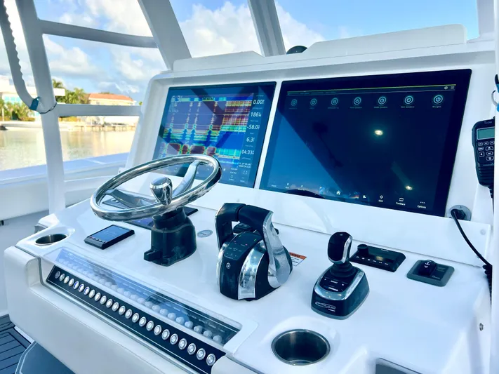 Lia Rose Yacht Photos Pics Control panel of 2022 Invincible 46 Catamaran with advanced navigation screens and steering wheel.