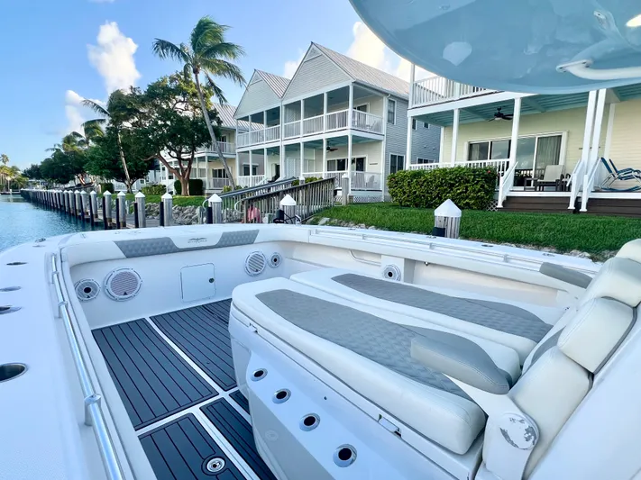 Lia Rose Yacht Photos Pics Invincible 46 Catamaran 2022 docked near waterfront homes, showcasing luxury seating and design.