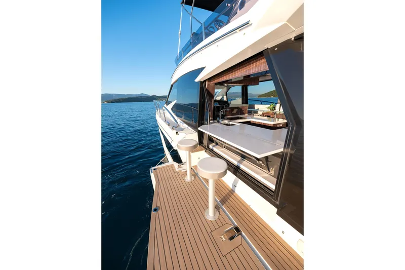  Yacht Photos Pics 2023 Galeon 500 Fly yacht with open deck and bar stools on calm sea.