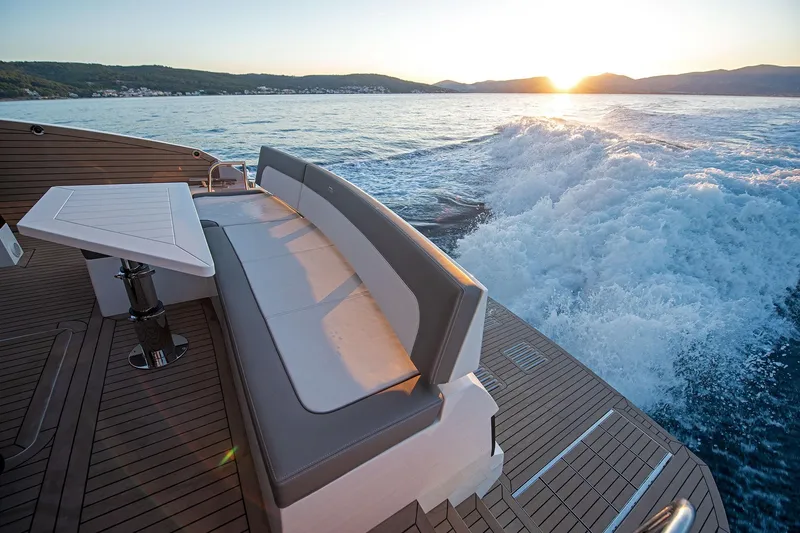  Yacht Photos Pics 2023 Galeon 500 Fly yacht deck with seating, table, and ocean view at sunset.