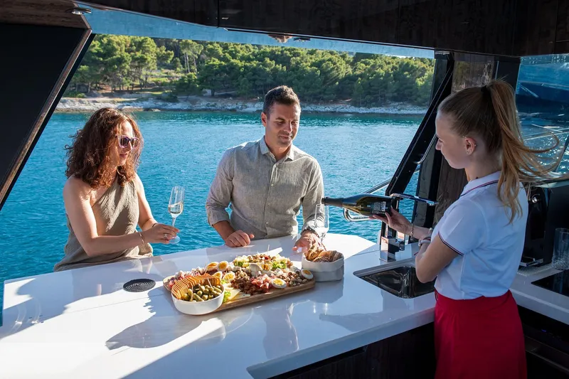  Yacht Photos Pics 2023 Galeon 500 Fly yacht with guests enjoying wine and appetizers on deck.
