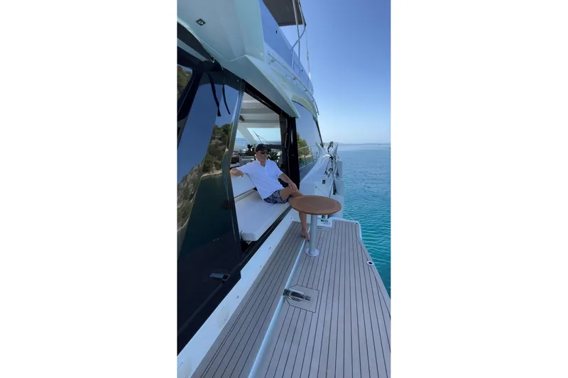  Yacht Photos Pics 2023 Galeon 500 Fly yacht with person relaxing on deck by the sea.