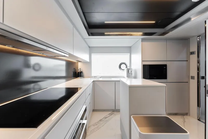 Chop Chop Yacht Photos Pics Modern kitchen interior on 2023 Riva Dolcevita yacht, featuring sleek white cabinetry and appliances.
