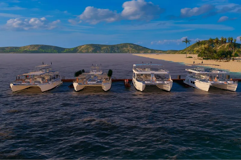  Yacht Photos Pics Five Custom PAXCAT 2027 catamarans docked at a scenic tropical beach.