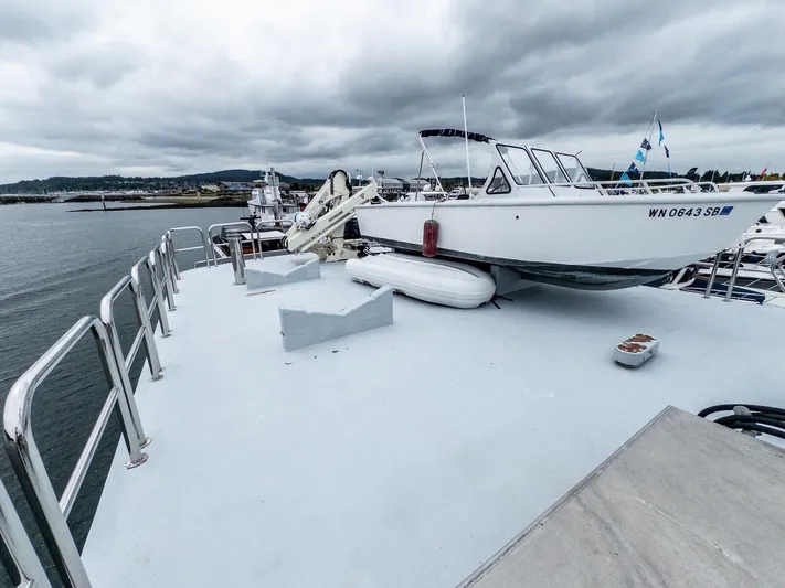 Starlight Yacht Photos Pics Custom Expedition Vessel 58 (1986) with small boat on deck, moored in a marina.