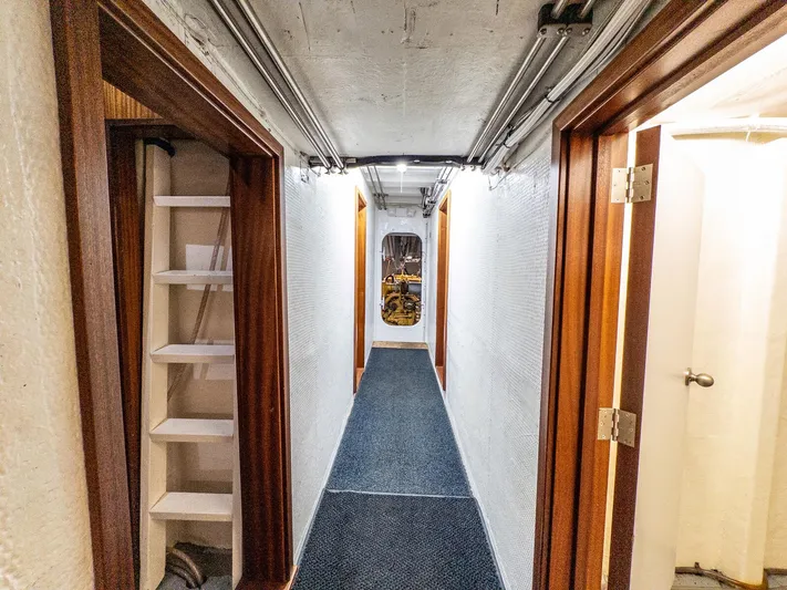 Starlight Yacht Photos Pics Narrow corridor inside 1986 Custom Expedition Vessel 58, featuring wooden doors and a ladder.