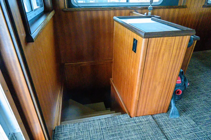 Starlight Yacht Photos Pics Staircase leading below deck on 1986 Custom Expedition Vessel 58, featuring wood paneling and carpeted floor.