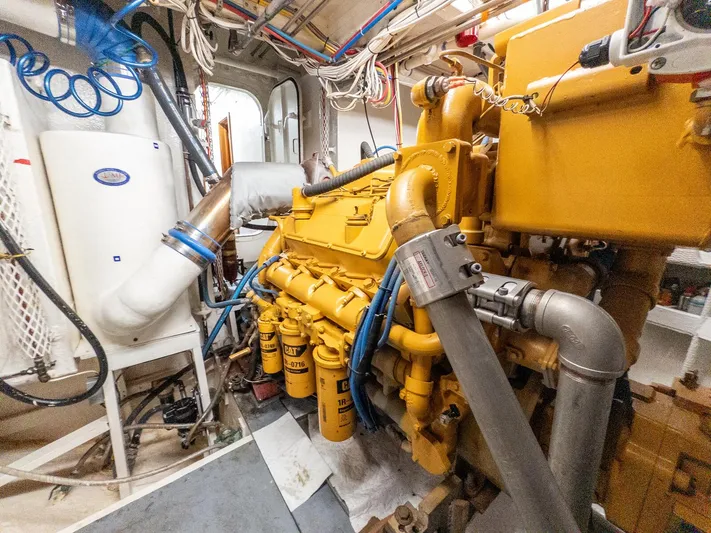 Starlight Yacht Photos Pics Engine room of 1986 Custom Expedition Vessel 58 with yellow machinery and piping.