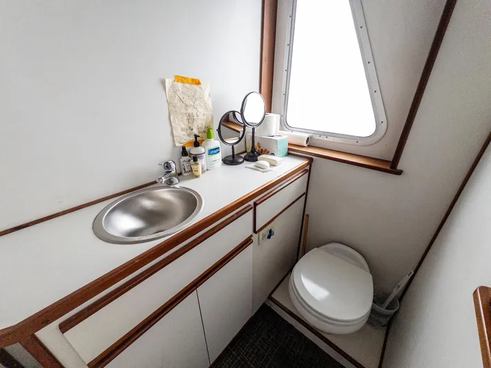 Starlight Yacht Photos Pics Compact bathroom in 1986 Custom Expedition Vessel 58 with sink, toilet, and window.