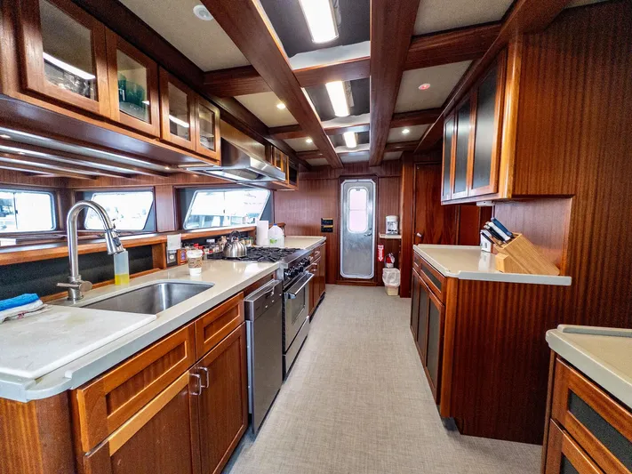 Starlight Yacht Photos Pics Luxurious kitchen interior of 1986 Custom Expedition Vessel 58 with wooden cabinetry and modern appliances.
