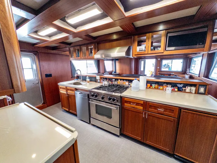 Starlight Yacht Photos Pics Spacious kitchen in 1986 Custom Expedition Vessel 58 with modern appliances and wooden cabinetry.