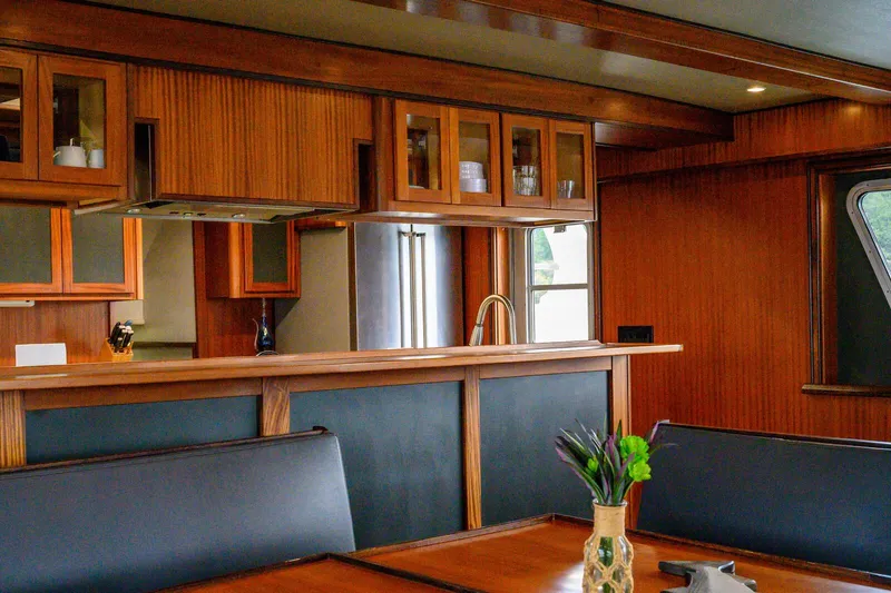 Starlight Yacht Photos Pics Luxurious interior of 1986 Custom Expedition Vessel 58 with wood paneling and modern kitchen.