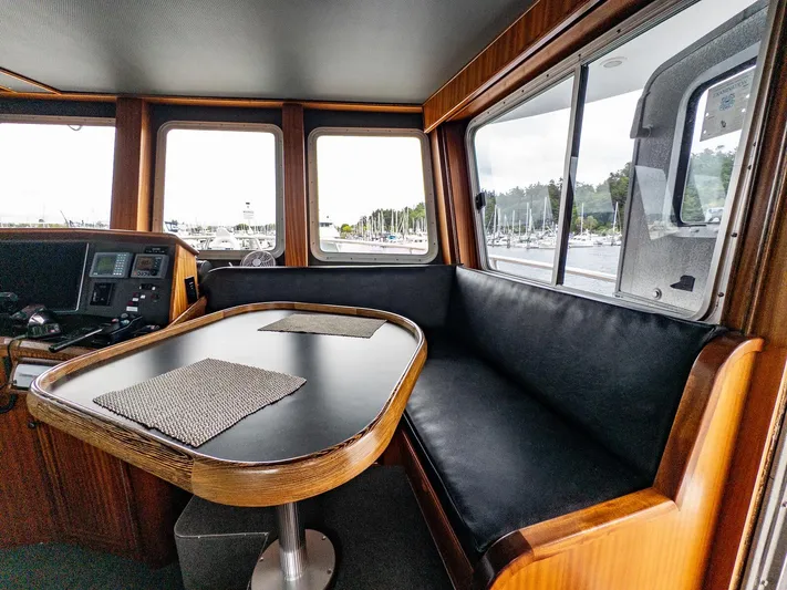 Starlight Yacht Photos Pics Interior of 1986 Custom Expedition Vessel 58 with seating and table, overlooking marina.