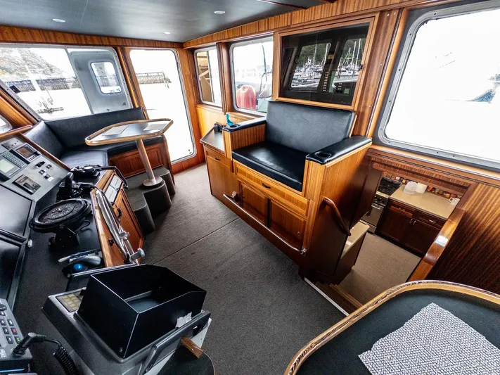 Starlight Yacht Photos Pics Pilothouse interior of 1986 Custom Expedition Vessel 58 with wood paneling and navigation equipment.
