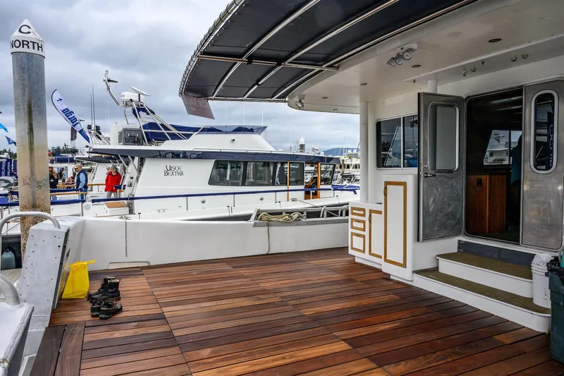 Starlight Yacht Photos Pics Expedition Vessel 58, 1986 model, docked with wooden deck and nearby boats.