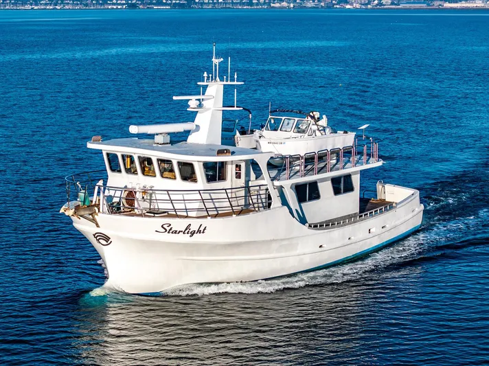 Starlight Yacht Photos Pics Custom Expedition Vessel 58, 1986, cruising on blue ocean waters.