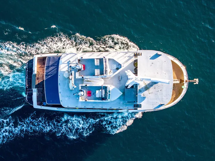 Starlight Yacht Photos Pics Aerial view of 1986 Custom Expedition Vessel 58 cruising through blue ocean waters.