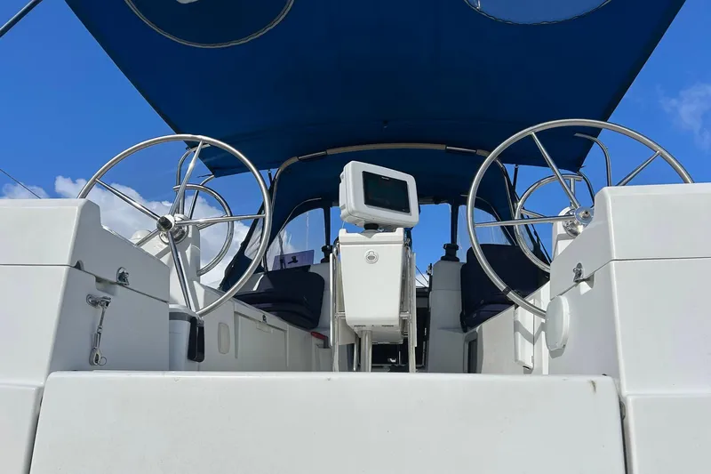 Layover Yacht Photos Pics 2018 Jeanneau Sun Odyssey 389 cockpit with dual steering wheels and blue canopy.