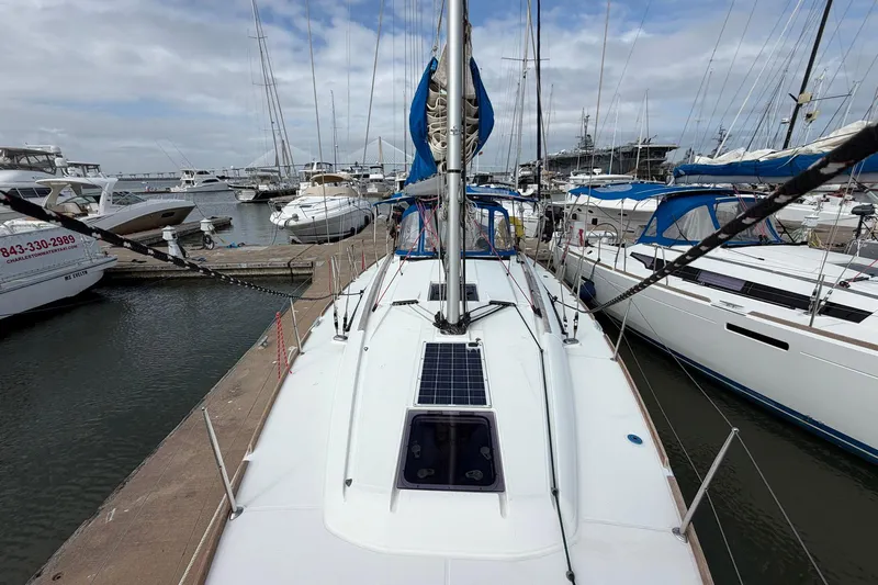 Layover Yacht Photos Pics 2018 Jeanneau Sun Odyssey 389 sailboat docked at a marina, surrounded by other boats.
