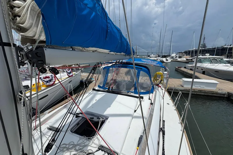 Layover Yacht Photos Pics 2018 Jeanneau Sun Odyssey 389 sailboat docked at marina, featuring blue sail cover.