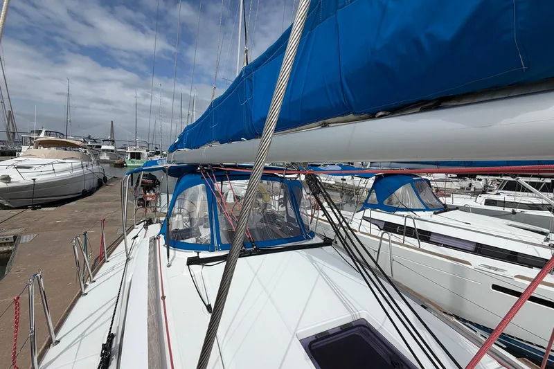 Layover Yacht Photos Pics 2018 Jeanneau Sun Odyssey 389 sailboat docked at marina, featuring blue sail cover.