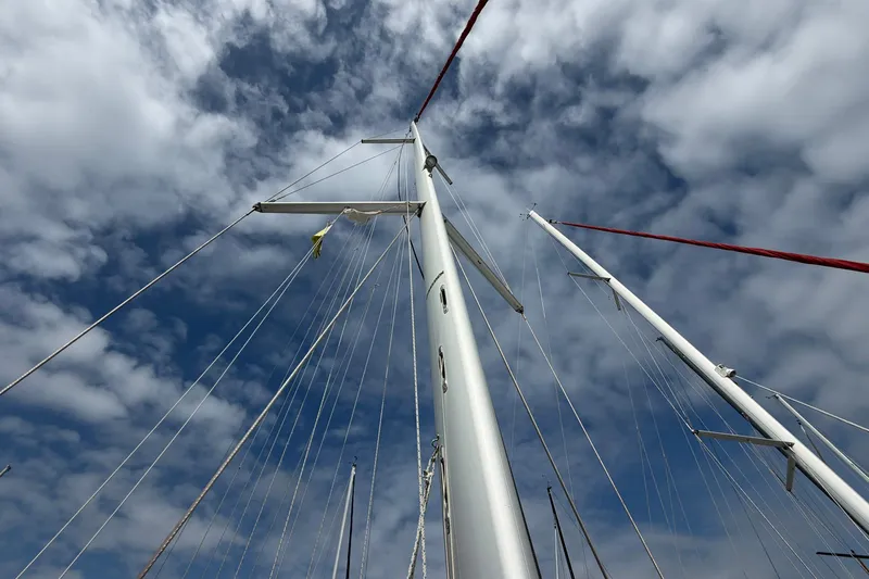 Layover Yacht Photos Pics Mast of 2018 Jeanneau Sun Odyssey 389 sailboat against a cloudy sky.