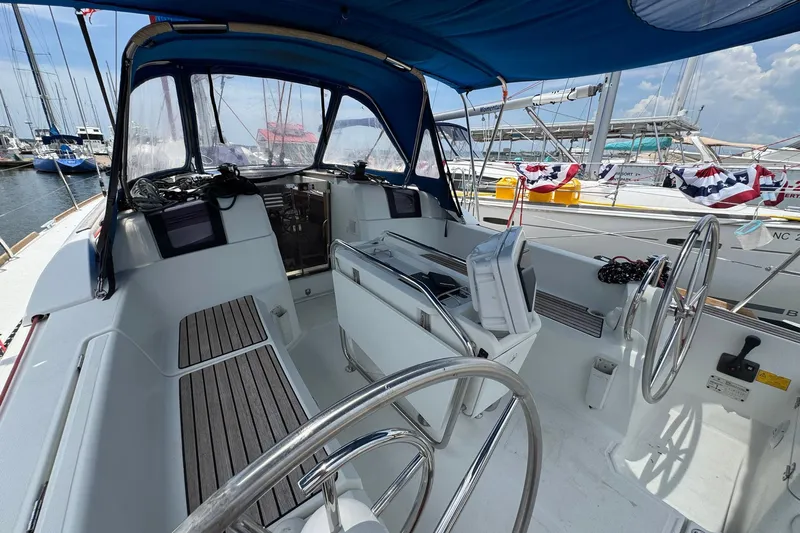 Layover Yacht Photos Pics Cockpit of 2018 Jeanneau Sun Odyssey 389 sailboat, featuring dual steering wheels and navigation equipment.