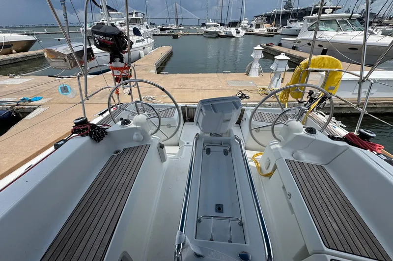 Layover Yacht Photos Pics 2018 Jeanneau Sun Odyssey 389 sailboat cockpit at marina, featuring dual steering wheels.