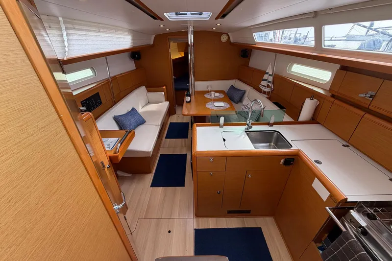 Layover Yacht Photos Pics 2018 Jeanneau Sun Odyssey 389 interior with modern kitchen and cozy seating area.