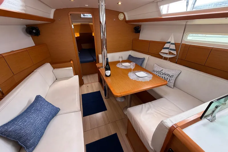 Layover Yacht Photos Pics 2018 Jeanneau Sun Odyssey 389 interior with cozy seating and dining area.