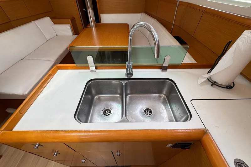 Layover Yacht Photos Pics Jeanneau Sun Odyssey 389 yacht interior, featuring a modern kitchen sink and seating area, 2018 model.