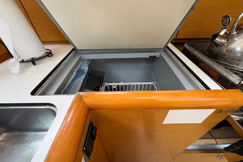 Layover Yacht Photos Pics 2018 Jeanneau Sun Odyssey 389 yacht kitchen with open fridge, sink, and kettle.